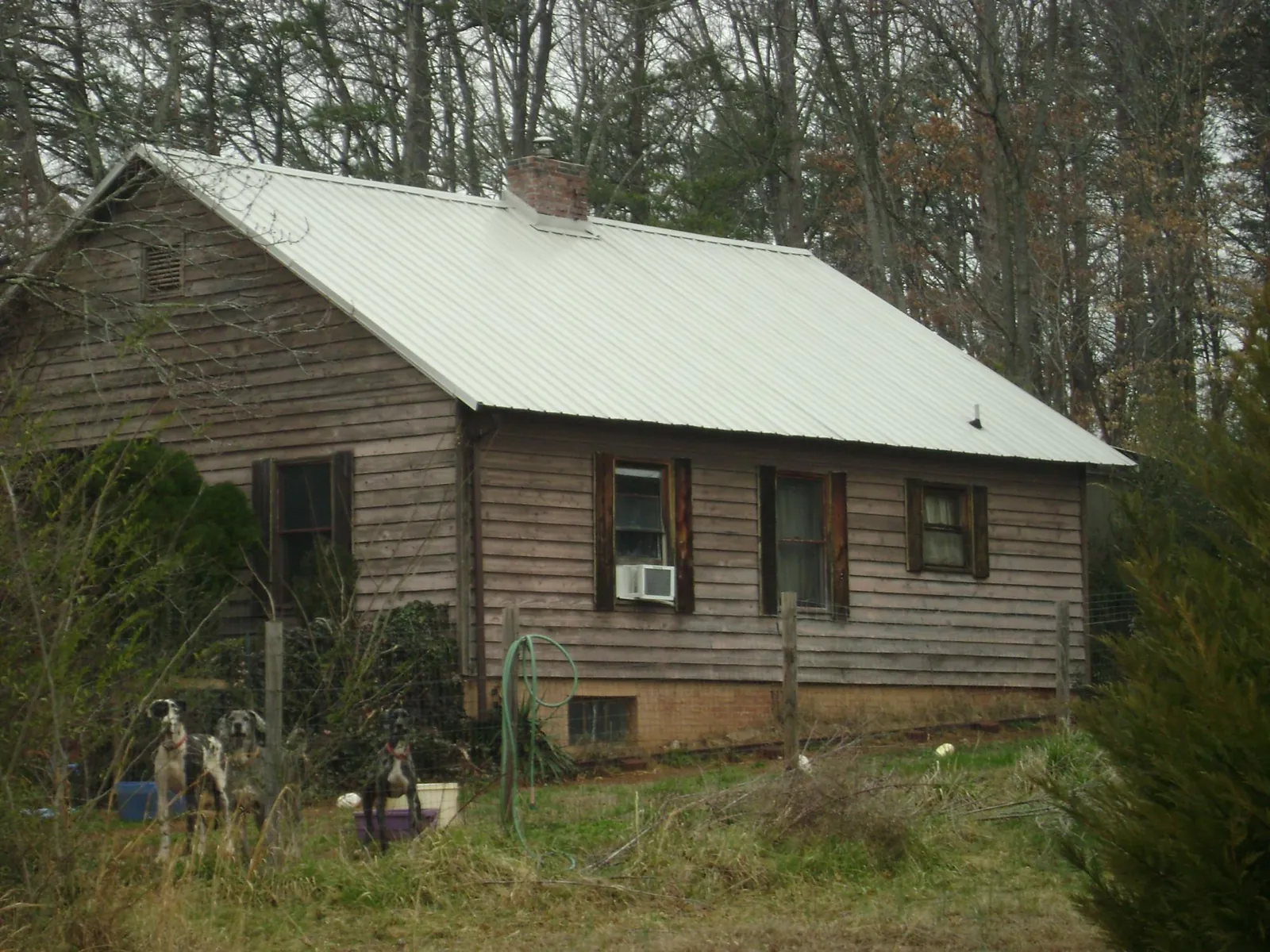 White metal roof on an old wood sided farmhouse, from a Metal Roof Installation job in Midlothian